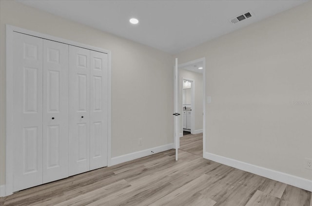 unfurnished bedroom with light hardwood / wood-style floors and a closet