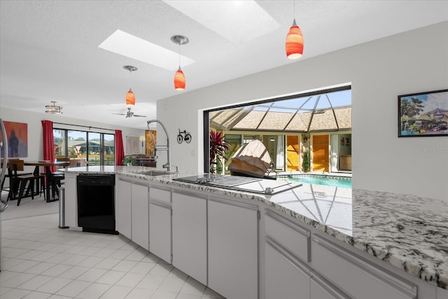 9 Crow Ct, Palm Coast, FL 32137 - kitchen featuring black dishwasher, stovetop with downdraft, a skylight, white cabinetry, and decorative light fixtures