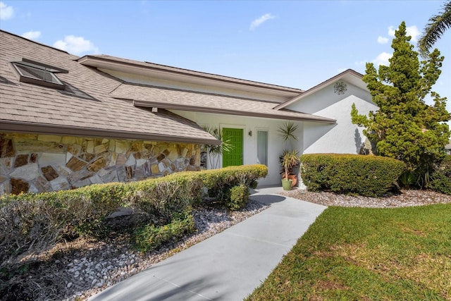 9 Crow Ct, Palm Coast, FL 32137 - view of exterior entry featuring stone siding and a shingled roof