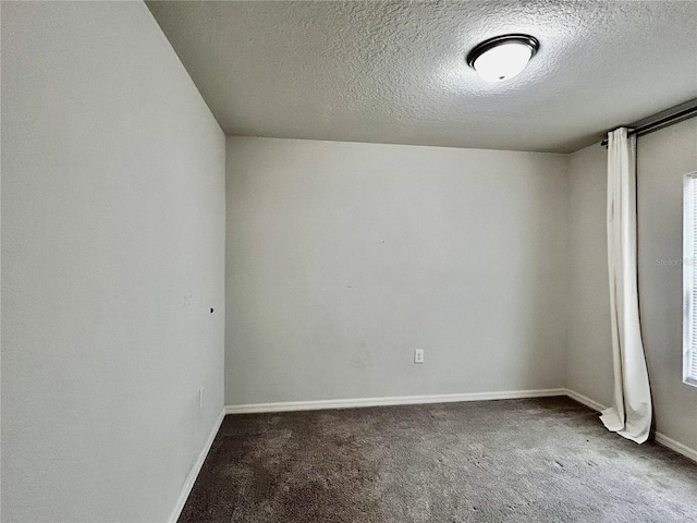 carpeted empty room featuring a textured ceiling