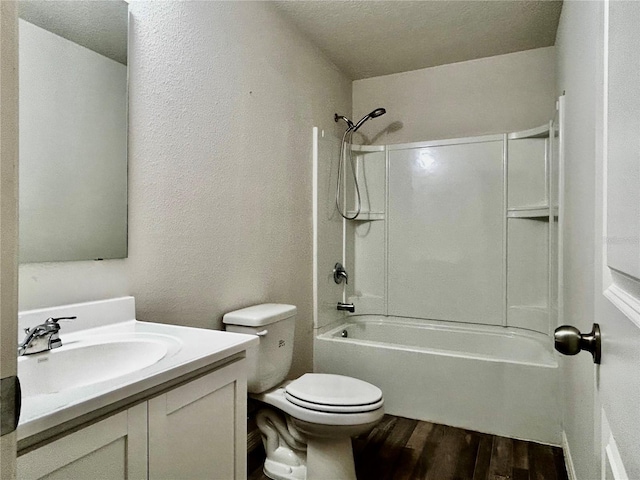 full bathroom featuring hardwood / wood-style floors, vanity, bathtub / shower combination, toilet, and a textured ceiling