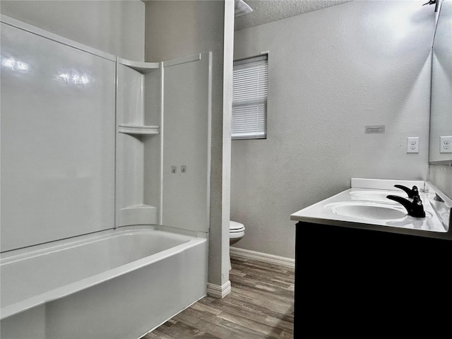 full bathroom featuring bathtub / shower combination, vanity, a textured ceiling, hardwood / wood-style floors, and toilet