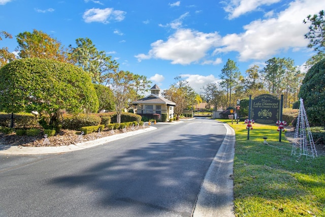 view of street with a gated entry and curbs