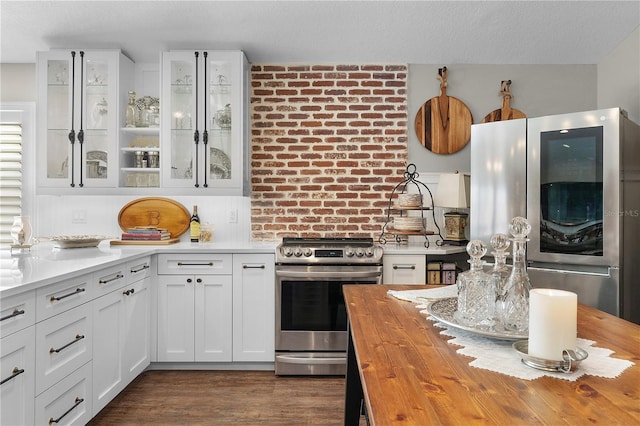 kitchen with wooden counters, dark hardwood / wood-style flooring, a textured ceiling, stainless steel appliances, and white cabinets