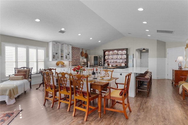 dining room with light hardwood / wood-style floors and vaulted ceiling