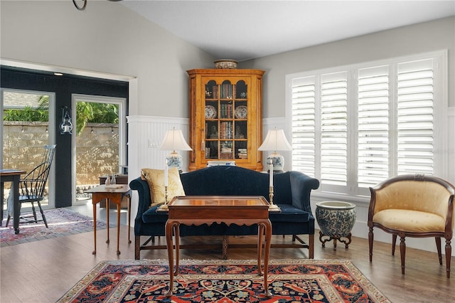 sitting room with hardwood / wood-style flooring, plenty of natural light, and vaulted ceiling