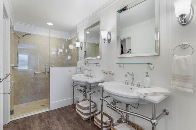 bathroom featuring dual sinks, ornamental molding, an enclosed shower, and hardwood / wood-style flooring