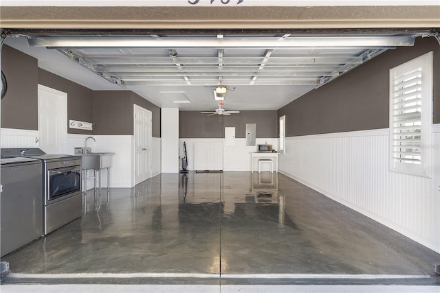 garage with washing machine and dryer, ceiling fan, sink, and electric panel