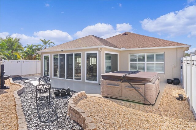 back of property with a patio and a hot tub