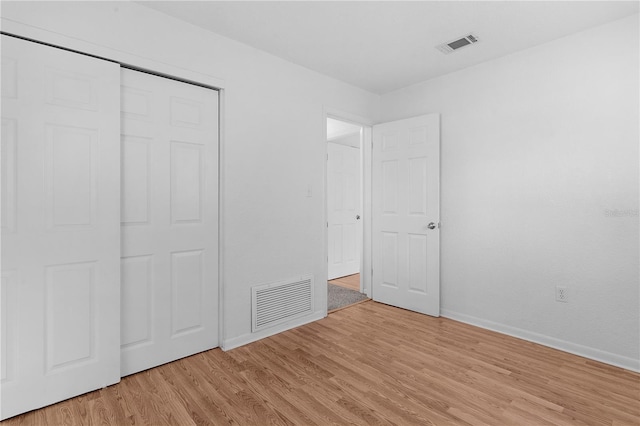 unfurnished bedroom featuring light hardwood / wood-style floors and a closet