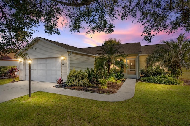 ranch-style house featuring a lawn and a garage