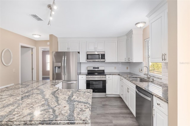 kitchen with white cabinets, stone countertops, sink, and appliances with stainless steel finishes