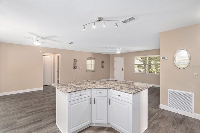 kitchen with dark hardwood / wood-style floors, a center island, and white cabinetry