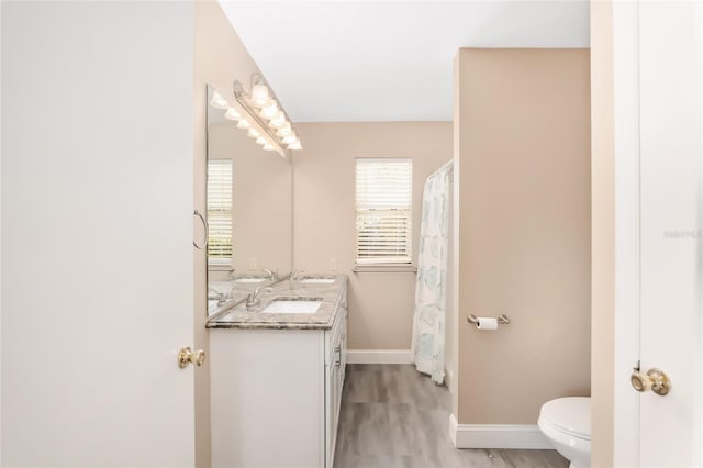 bathroom with a shower with curtain, vanity, hardwood / wood-style flooring, and toilet