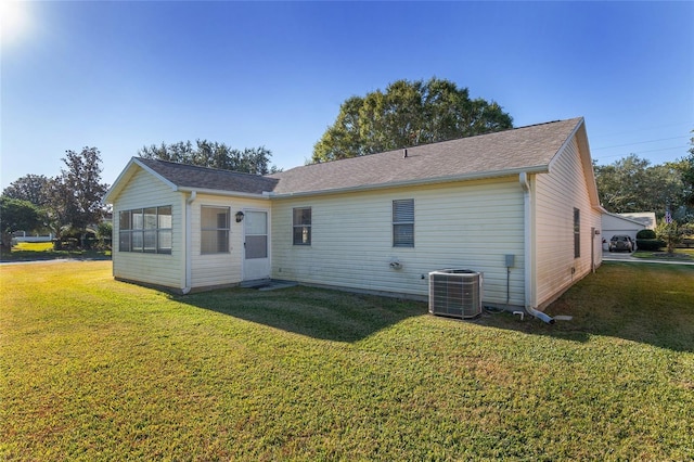 rear view of property with a lawn and central AC unit