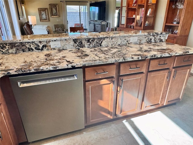 kitchen featuring stone counters, light tile patterned floors, and stainless steel dishwasher