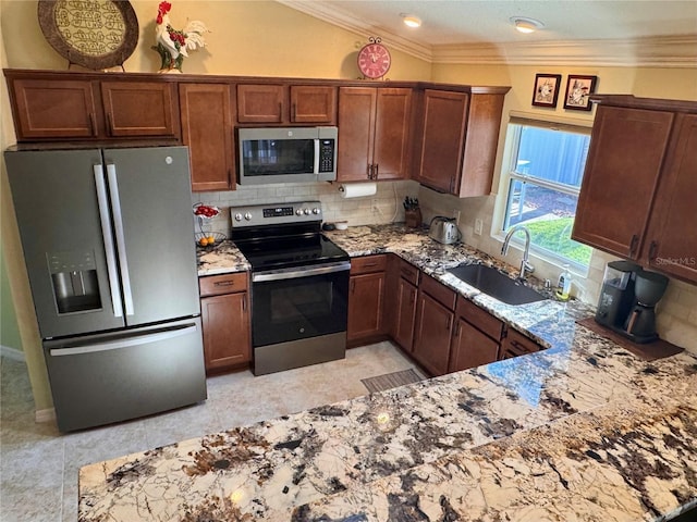 kitchen with light stone countertops, appliances with stainless steel finishes, backsplash, and sink