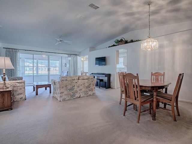 dining space featuring lofted ceiling, light colored carpet, and ceiling fan