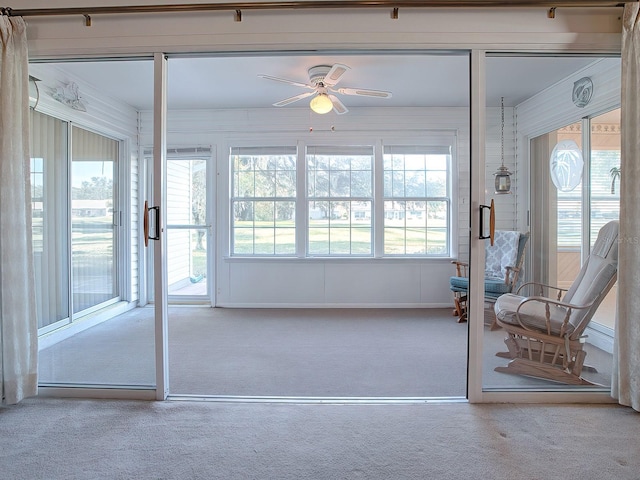 unfurnished sunroom featuring ceiling fan