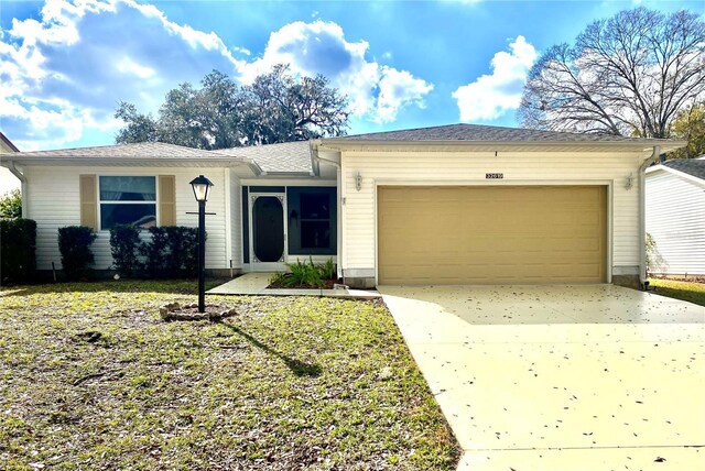 ranch-style house featuring a garage and a front lawn