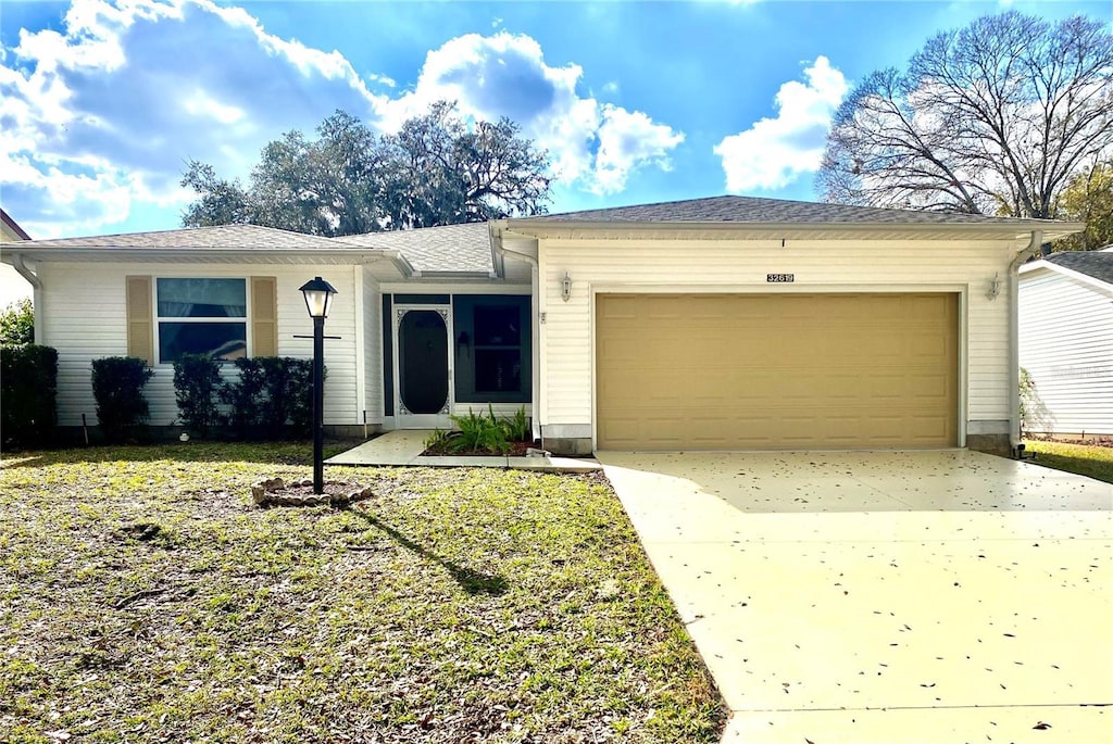 ranch-style house with a garage and a front yard