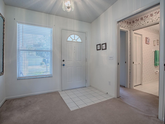 carpeted entryway featuring a textured ceiling