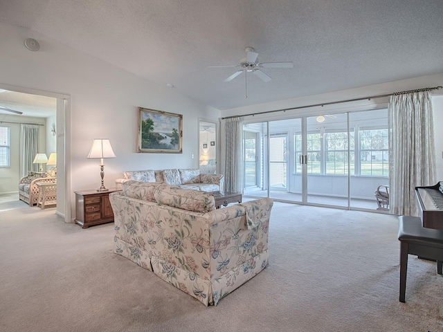 carpeted living room featuring ceiling fan, vaulted ceiling, and a textured ceiling