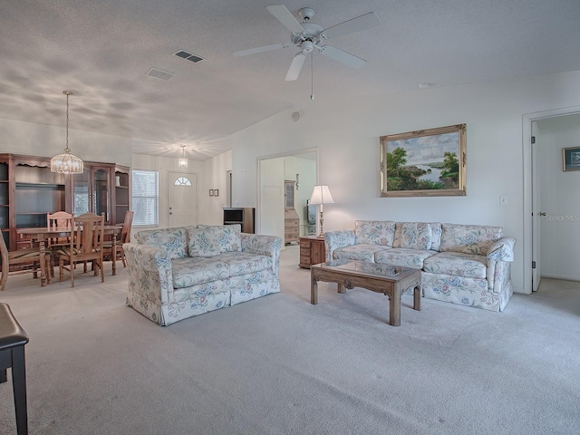 carpeted living room featuring ceiling fan, lofted ceiling, and a textured ceiling