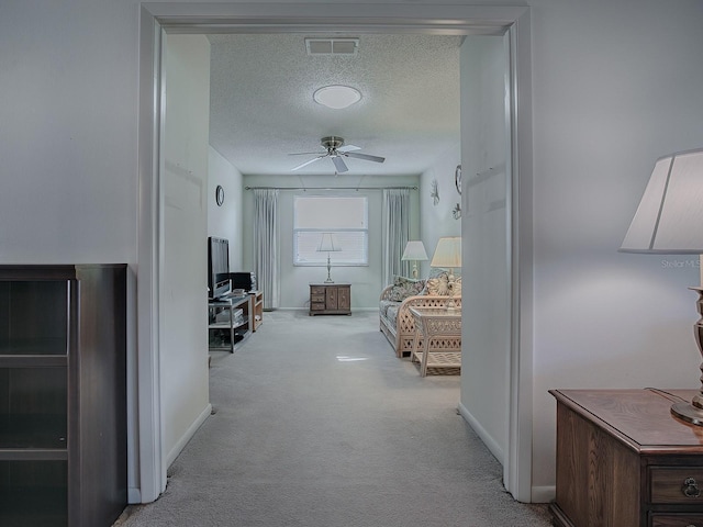 bedroom featuring light carpet and a textured ceiling