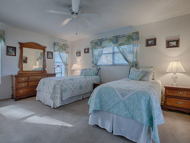 bedroom featuring ceiling fan, light colored carpet, multiple windows, and a textured ceiling