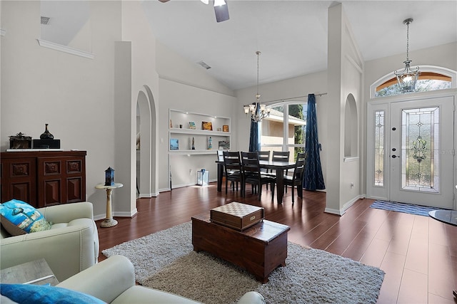 living room featuring a healthy amount of sunlight, dark hardwood / wood-style flooring, and built in shelves