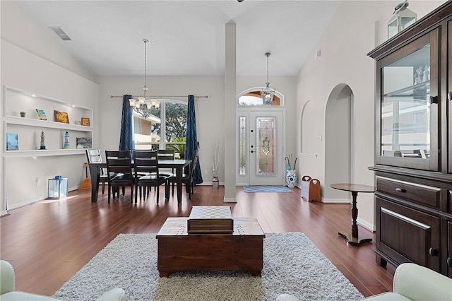 living room featuring vaulted ceiling, a chandelier, and hardwood / wood-style floors