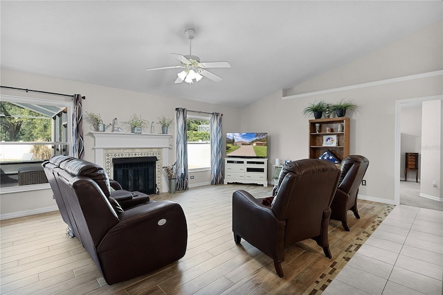 living room with vaulted ceiling, ceiling fan, and light wood-type flooring