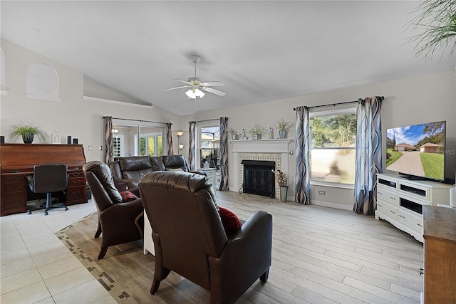 living room featuring light hardwood / wood-style flooring, vaulted ceiling, and ceiling fan