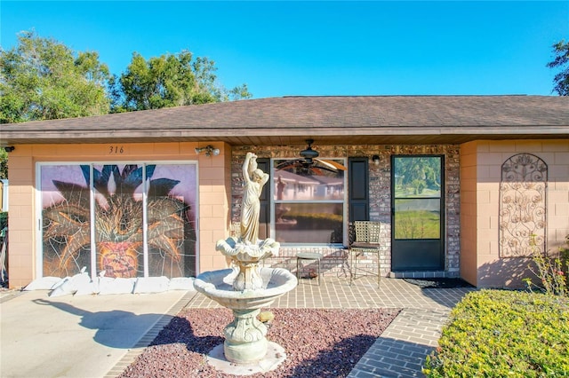 view of exterior entry featuring ceiling fan and a patio area