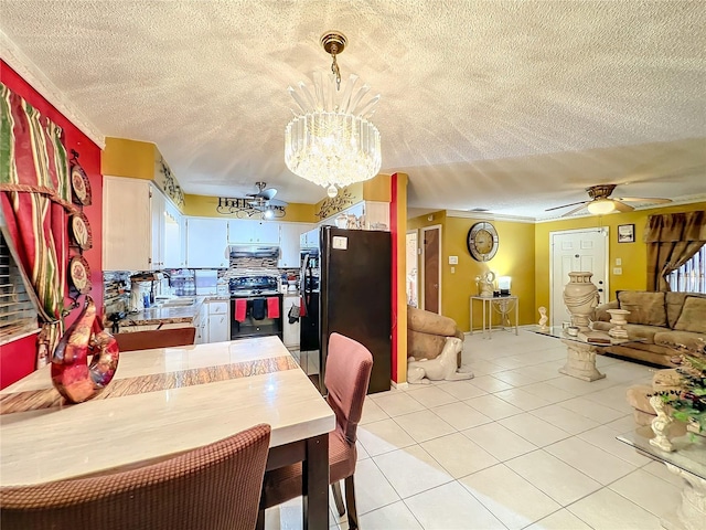 tiled dining area with a textured ceiling, ceiling fan with notable chandelier, and sink