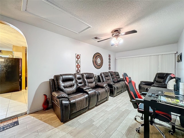 interior space featuring ceiling fan, light hardwood / wood-style flooring, and a textured ceiling