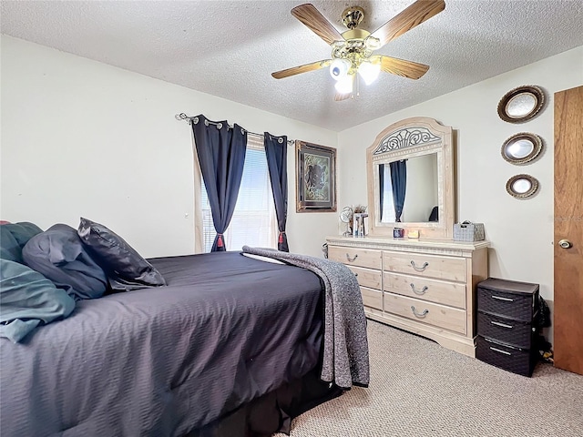 carpeted bedroom with ceiling fan and a textured ceiling