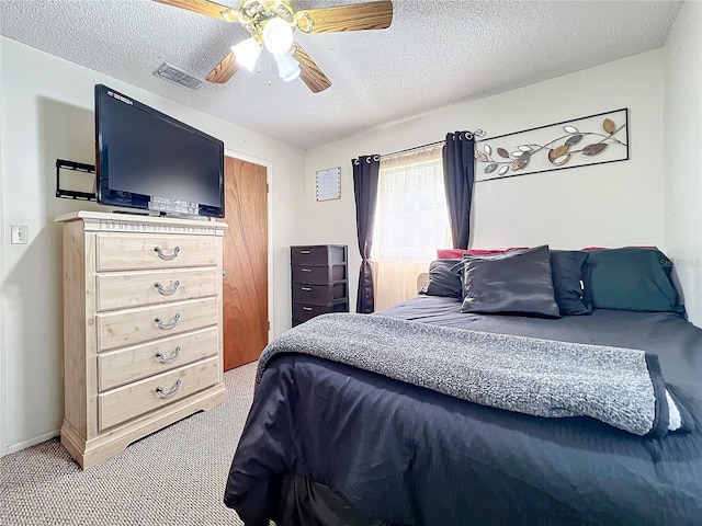 bedroom with carpet, ceiling fan, and a textured ceiling