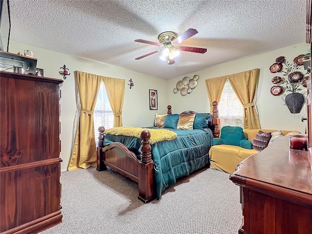 carpeted bedroom featuring multiple windows, a textured ceiling, and ceiling fan