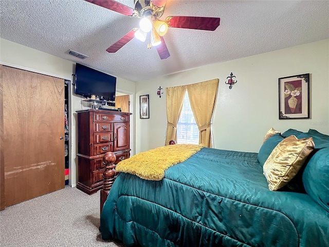 carpeted bedroom featuring ceiling fan, a textured ceiling, and a closet