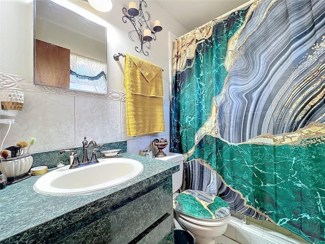 bathroom with vanity, tile walls, and toilet