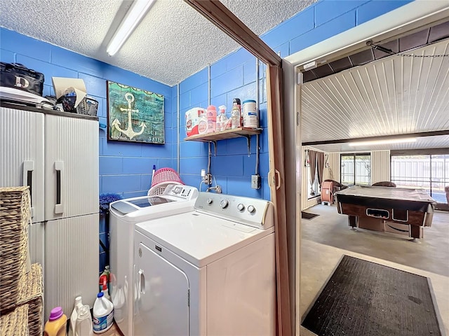 clothes washing area featuring independent washer and dryer, a textured ceiling, and pool table