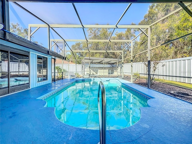 view of swimming pool featuring a lanai