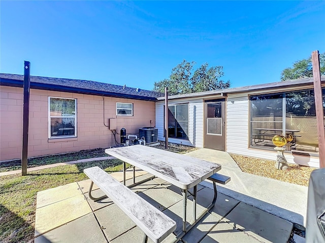 rear view of house with central AC unit and a patio area