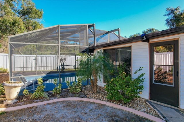 exterior space with a lanai and a fenced in pool