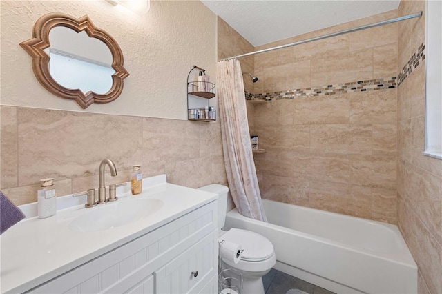 full bathroom featuring shower / bathtub combination with curtain, a textured ceiling, toilet, vanity, and tile walls