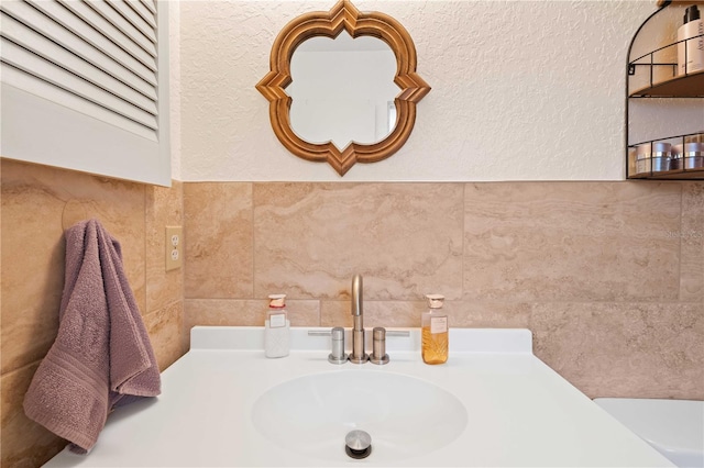 bathroom with sink and tile walls