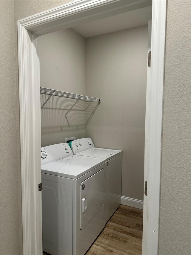 laundry room featuring washing machine and clothes dryer and light wood-type flooring