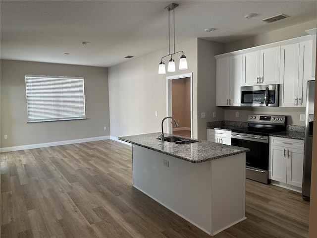 kitchen with sink, a center island with sink, white cabinets, and appliances with stainless steel finishes